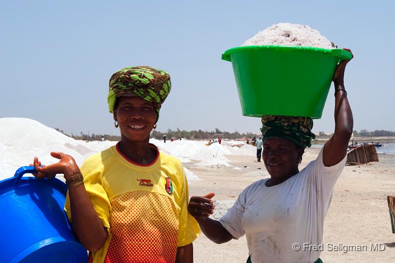 20090529_132336 D3 P1 P1.jpg - Two woman working to gather the salt.  The salt is harvested from the bottom of the lake usually by men who place it in a canoe.    Then a worker, usually a woman carries the sand to shore in a 130 lb basin on her head.  The basin is transferred 3 or more times in the trek to the shore, almost like a relay race.